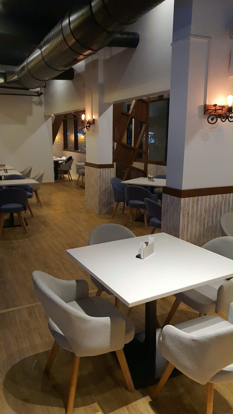 EN'CREO BISTRO dining area with tables, chairs and exposed ductwork