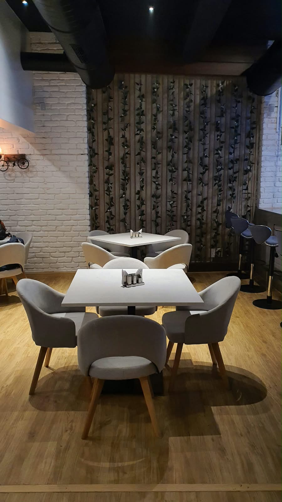 EN'CREO BISTRO dining tables and seating facing a decorative wall